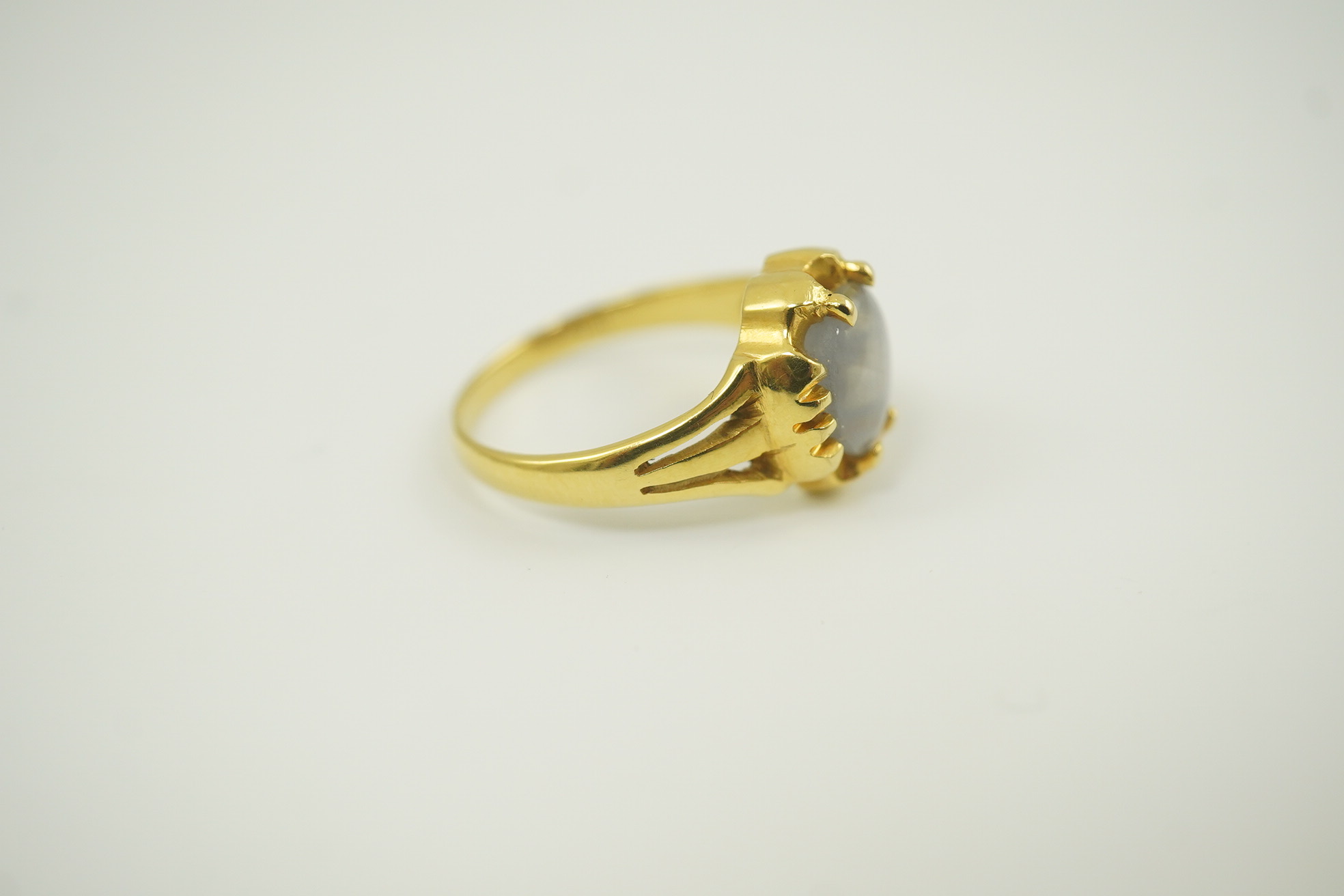 A modern 18k gold and single stone cabochon star sapphire set ring